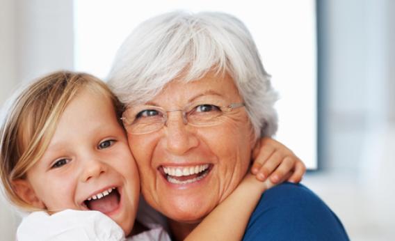 elderly woman hugging her grandchild and touching heads, being cautious of head lice because adults get head lice too