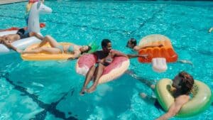 family swimming with floaties in swimming pool