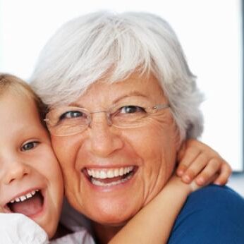 elderly woman hugging her grandchild and touching heads, being cautious of head lice because adults get head lice too